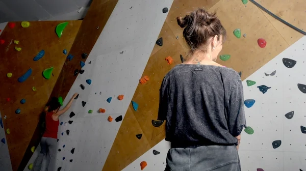 Raquel, monitora de Planet Vertical en Alcalá de Henares, poniéndose los gatos para escalar