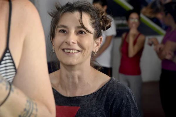 Raquel, monitora de Planet Vertical, en Alcalá de Henares, sonriendo mientras observa la técnica de una socia que está escalando