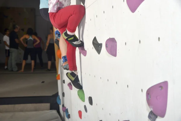 peques escalando, con socios de Planet Vertical al fondo, charlando