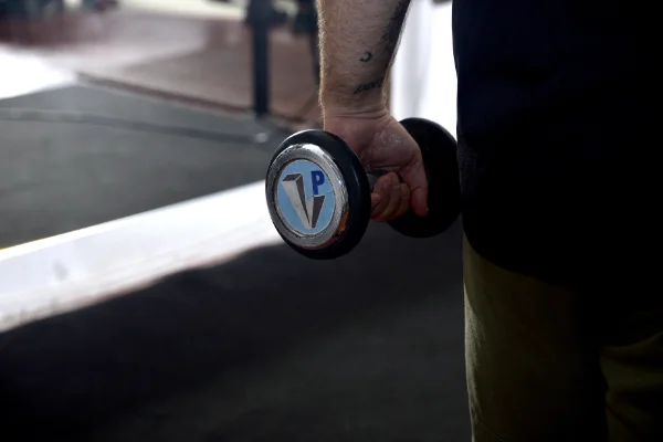 la mano de un socio de Planet Vertical, en Alcalá de Henares, con una pesa cogida durante un entrenamiento de la clase de fitness