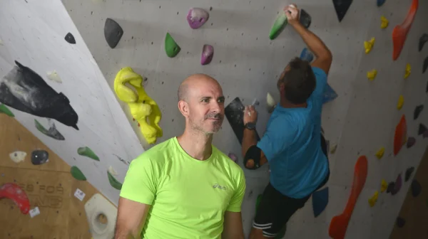 Samu, socio de Planet Vertical, en Alcalá de Henares, observando a otro socio escalando, con otra persona detrás también escalando