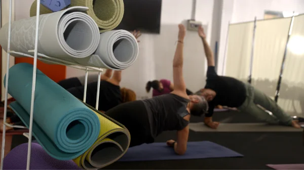 clase de yoga en Planet Vertical, en Alcalá de Henares, con una serie de esterillas enrolladas en primer plano